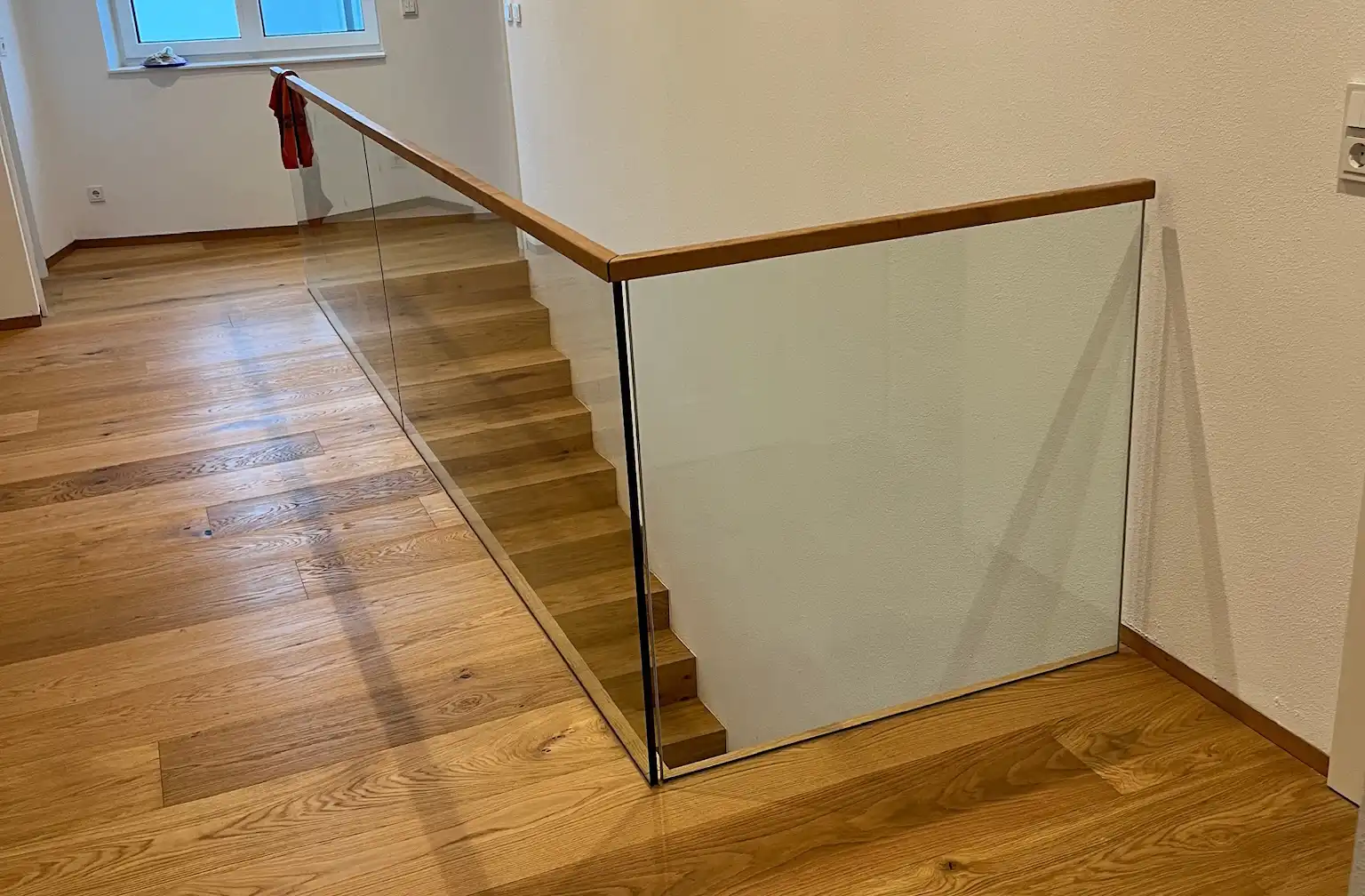 Glasgeländer mit Handlauf aus Holz