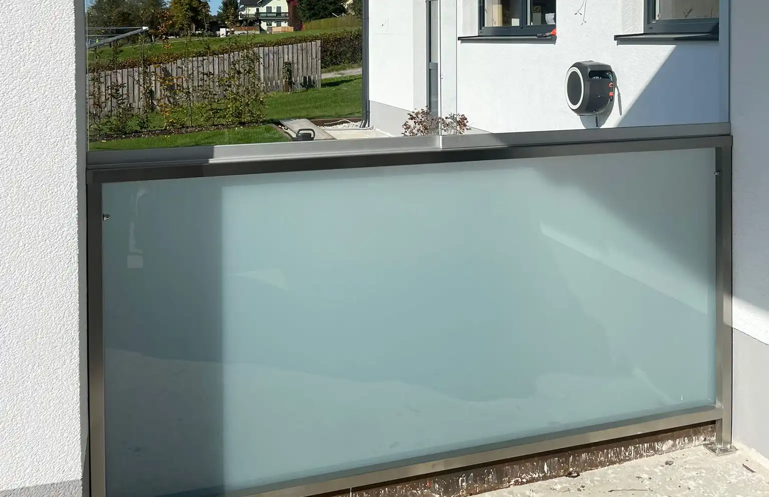 Windschutz aus Glas und Metall für Terrasse