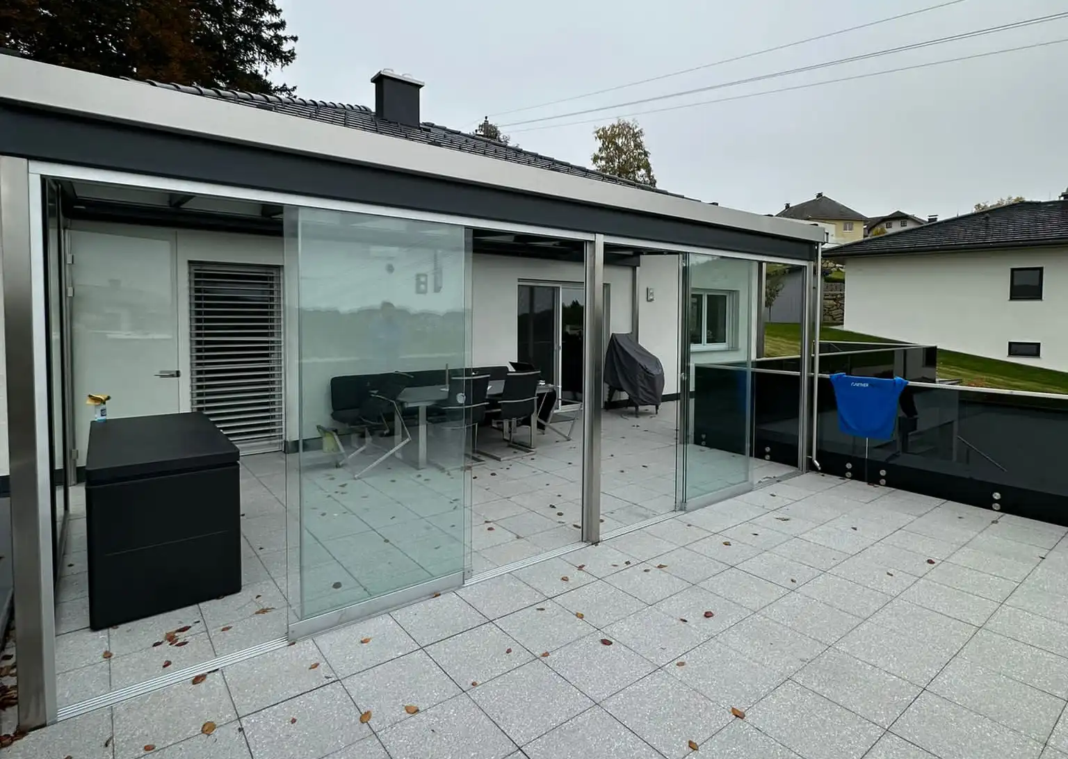 Überdachung Terrasse mit Schiebeglaselementen als Windschutz
